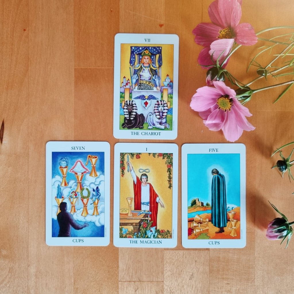 A three-card tarot spread with flowers in the corner.