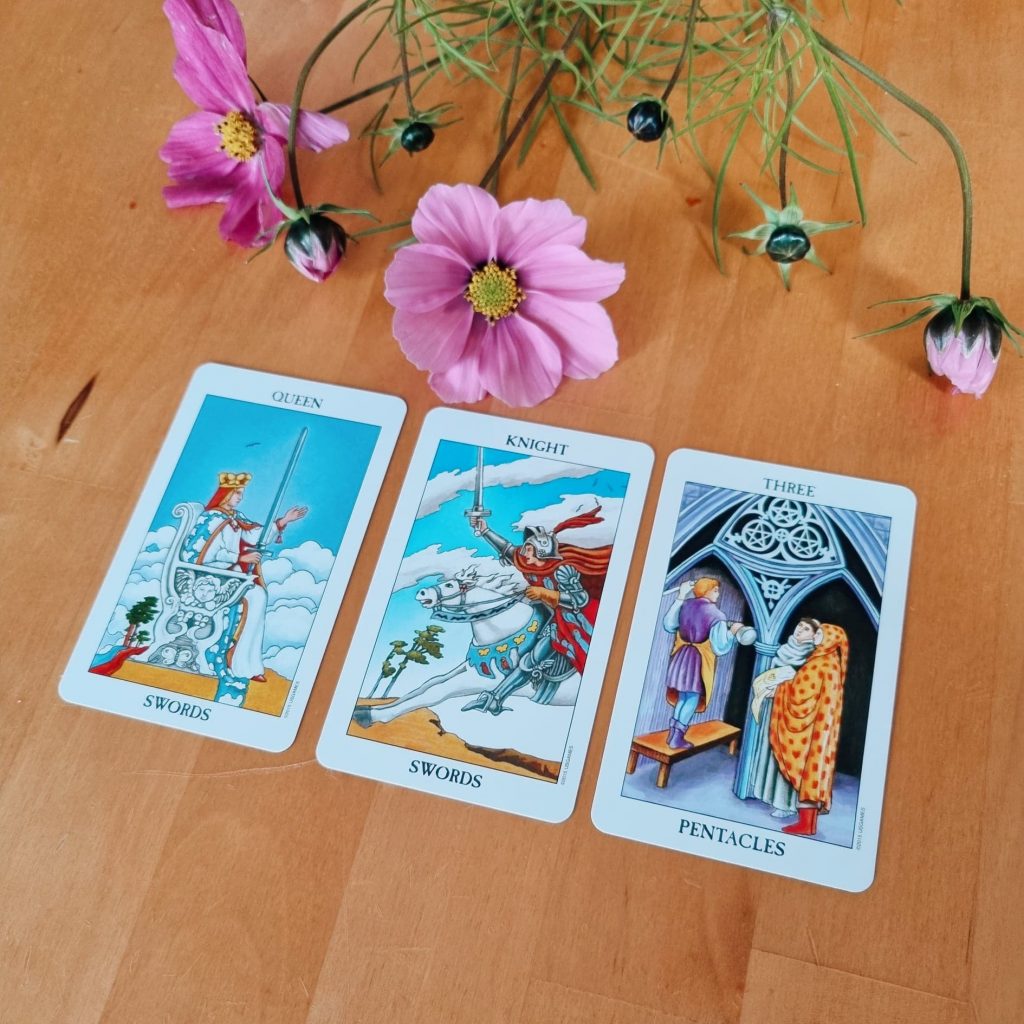 A three-card spread with flowers in the upper part of the photo. 